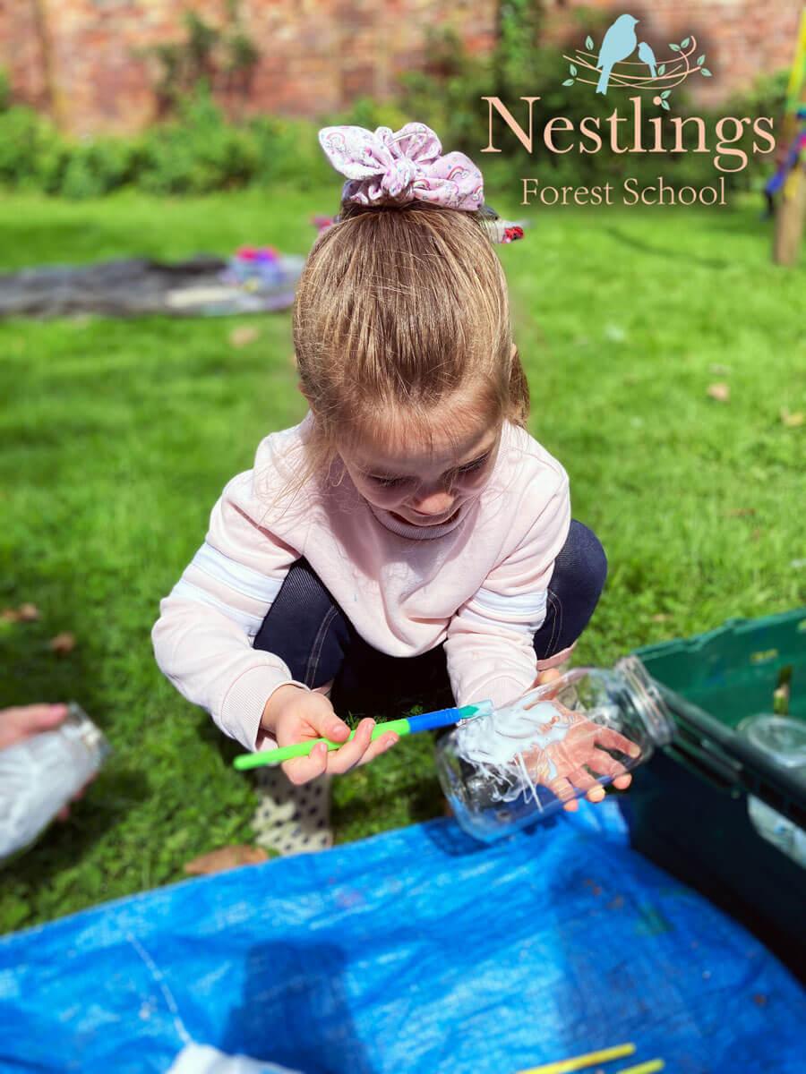 little girl painting jar